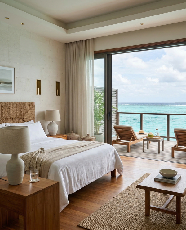 Indoor-outdoor master bedroom suite opening to a teak deck and turquoise lagoon.